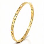 Gold bangle bracelet with Roman numerals and cubic zirconia accents